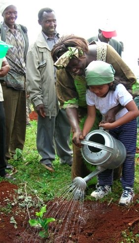 photo of Dr Wangari Maathai watering a young tree with girl